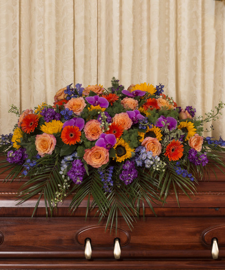 Casket spray of vibrant assorted flowers.