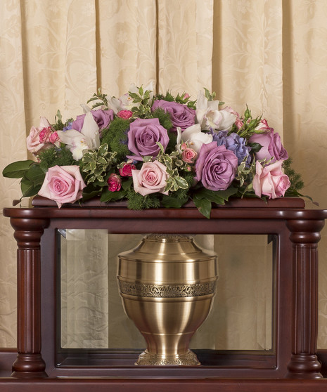 Floral arrangement of pastel roses and orchids to adorn the top of an urn ark. 