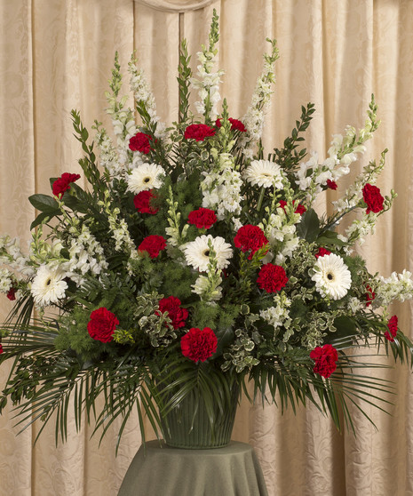 Red and white funeral basket of snapdragons, gerbera daisies, carnations and more.
