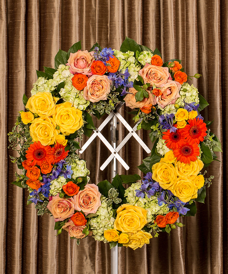 Funeral wreath of assorted flowers in bold colors. 
