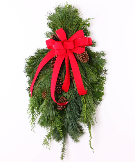 Assorted fresh mixed greens incluiding cedar, white pine, douglas and silver fir tied with a bow. 