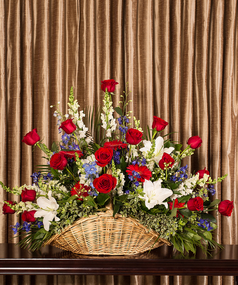 Fireside basket filled with red, white and blue flowers for a patriotic tribute.