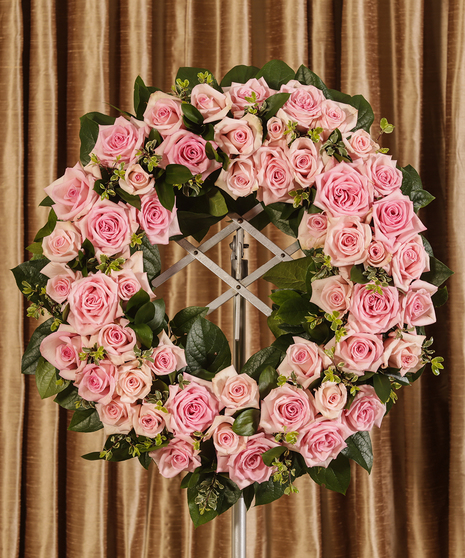 Sympathy wreath of pink roses and greenery. 