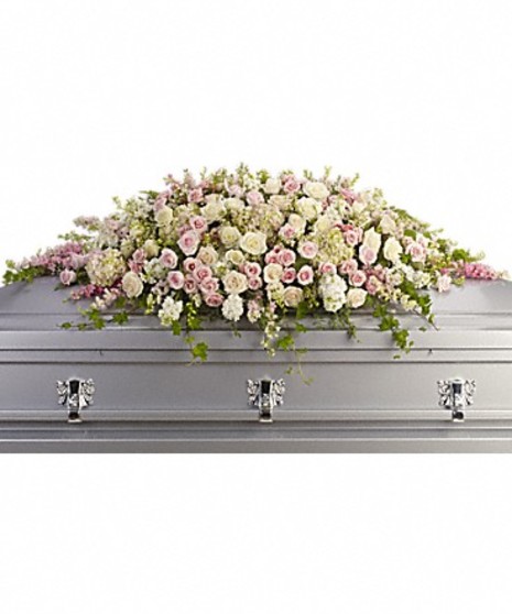 Casket spray of pink, white and creme flowers and greenery. 